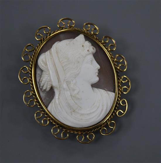 A 9ct mounted oval cameo brooch, carved with the bust of a lady to sinister, with scrolling border, 50mm.